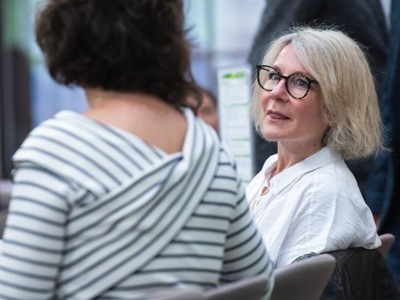 Two delegates engaged in discussion following a talk in the Elements Suite