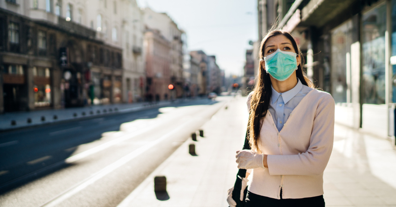 Concerned woman outdoors with a face mask