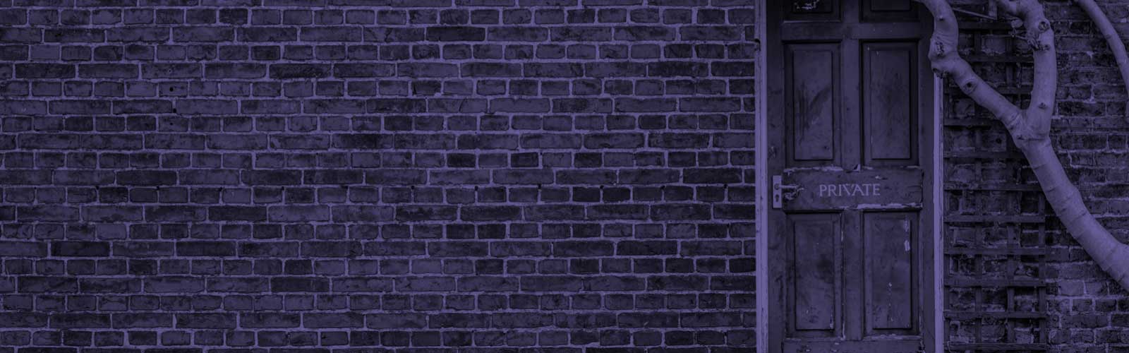 A brick house with a front door that reads 'PRIVATE' across the centre