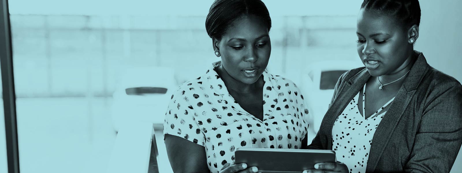  Two woman in conversation looking at a tablet