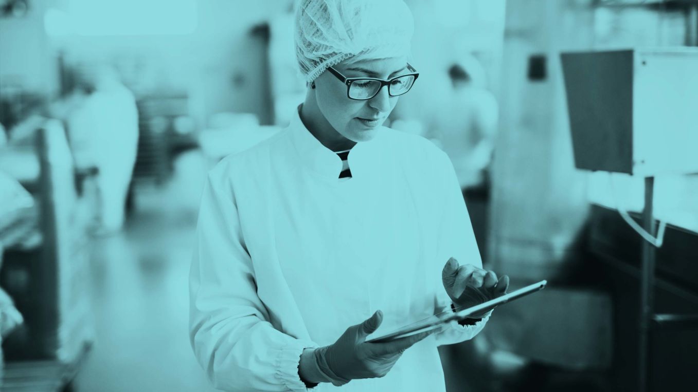 Woman in a lab coast using a tablet