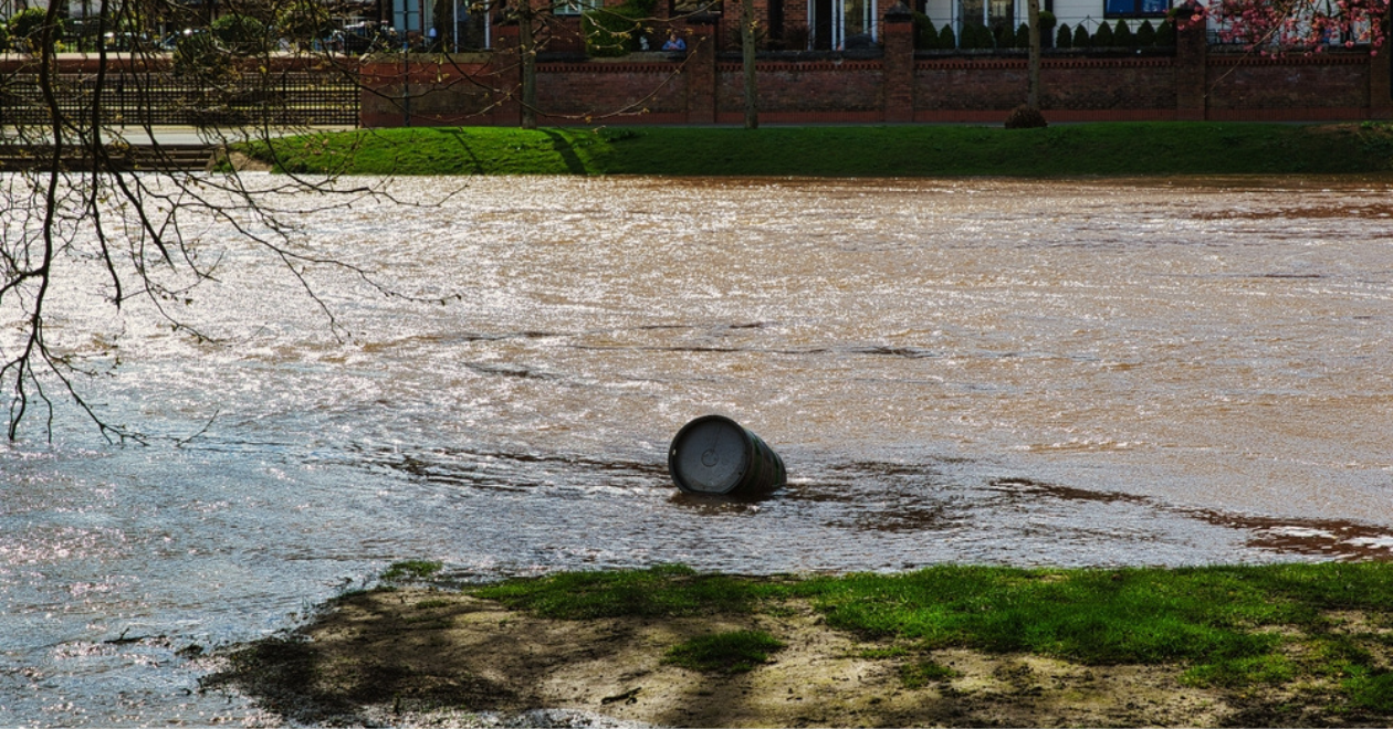 Polluted river with a discarded tire floating on the water's surface