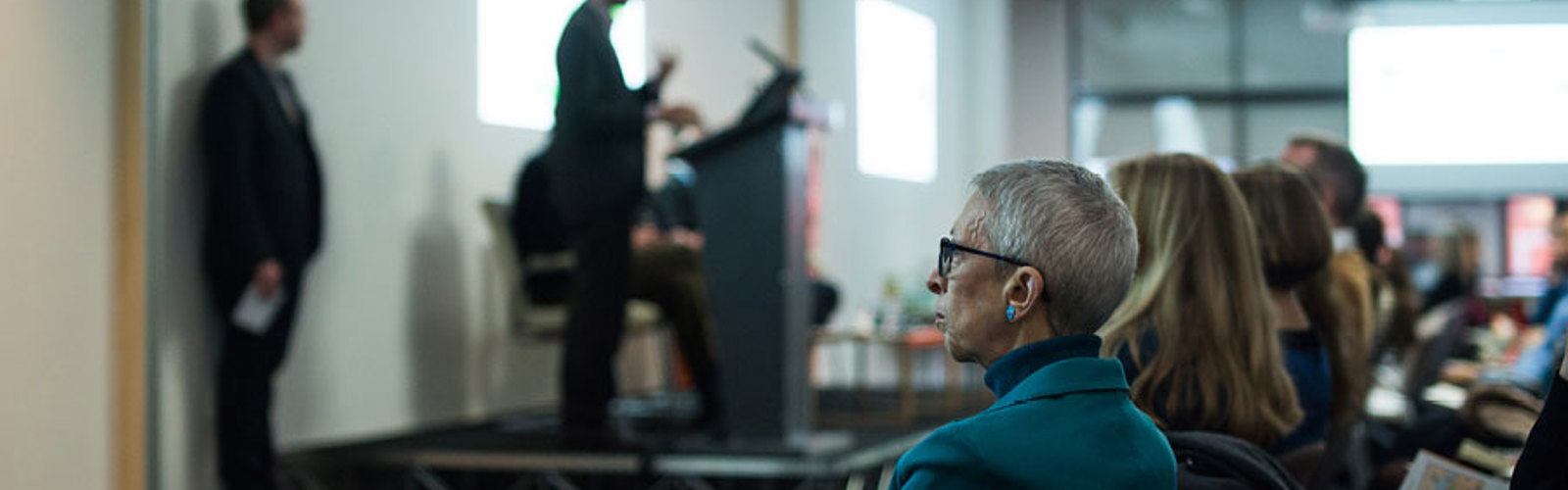 People speaking to a room of delegates