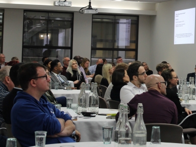 Delegates seated cabaret style for speaker session in the Elements Suite