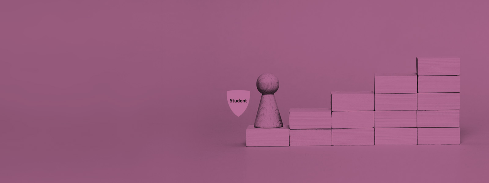 Student badge with a wooden pawn on the first step of a tower of blocks