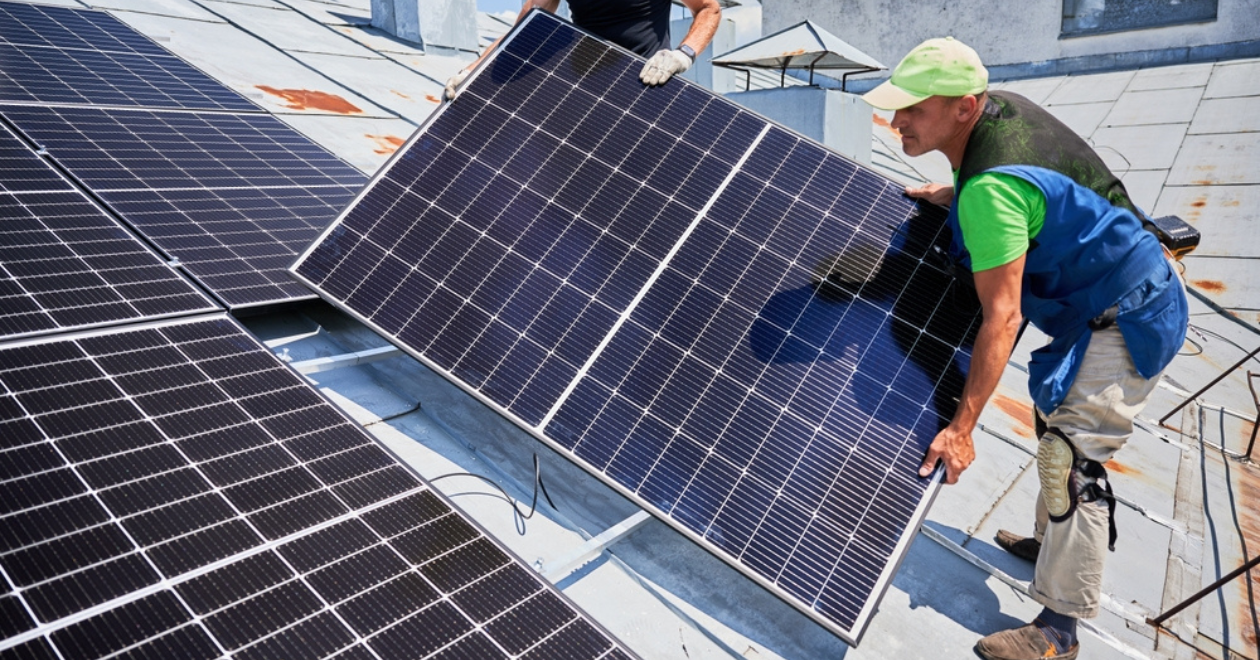 Engineers installing solar panels on house roof