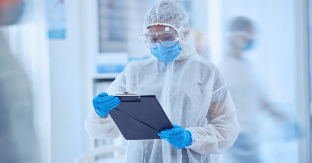 Doctor wearing PPE looking at notes