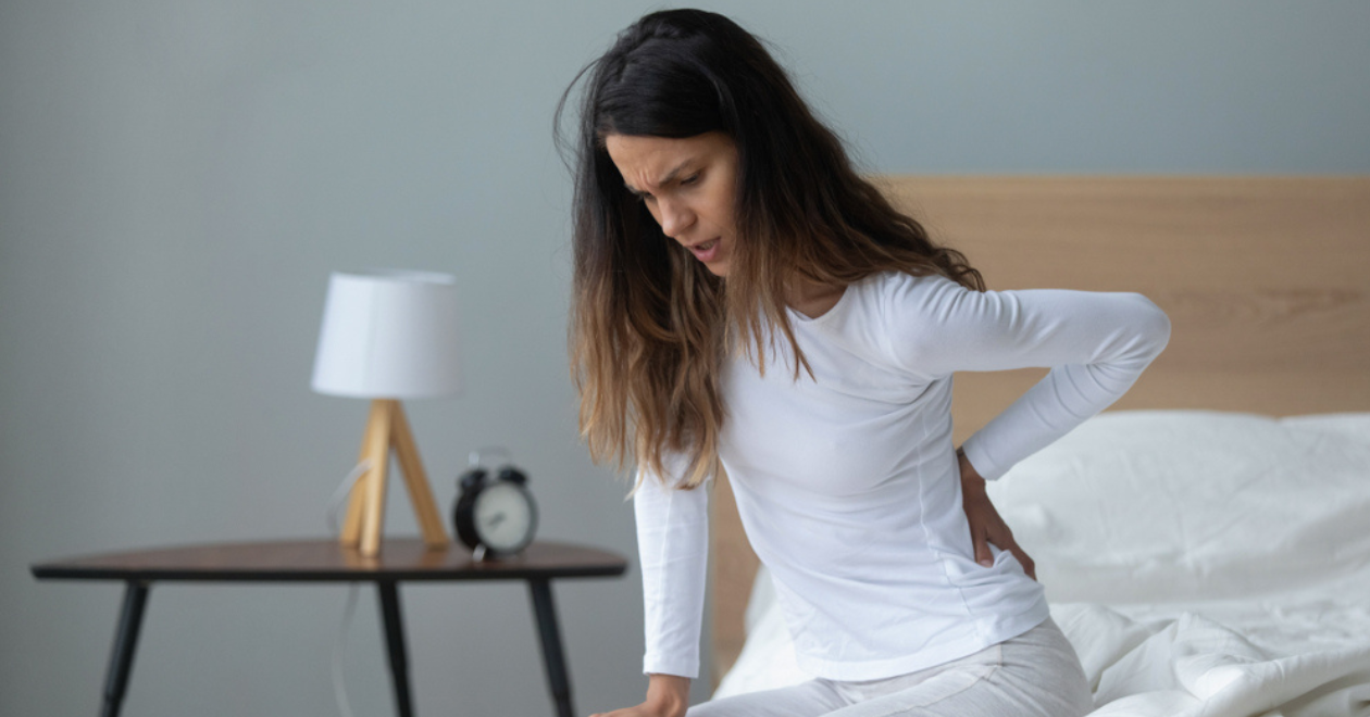 Woman getting out of bed in pain